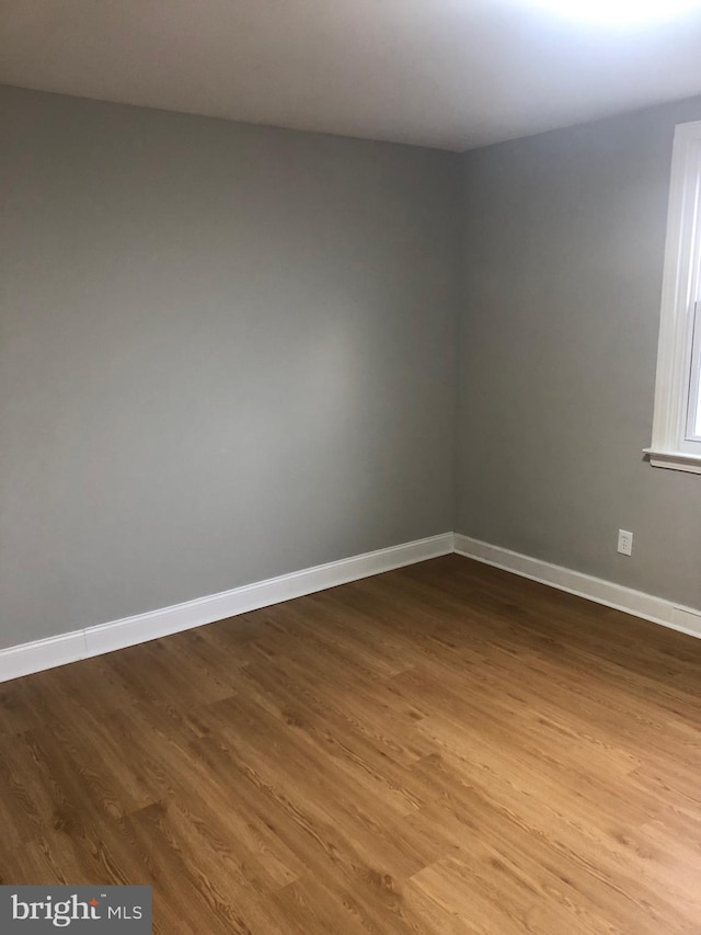 unfurnished room with wood-type flooring