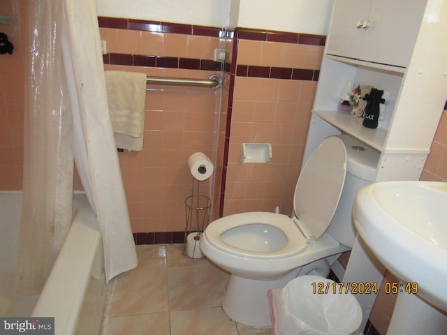 full bathroom with tile patterned floors, tile walls, and shower / bath combo with shower curtain