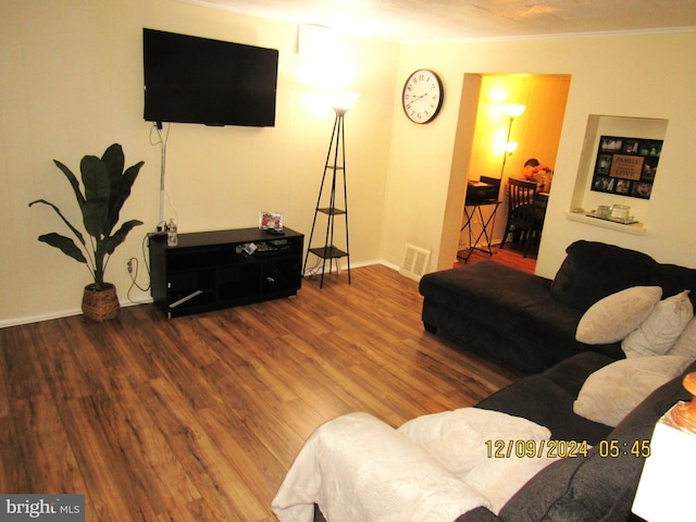 living room with crown molding and hardwood / wood-style floors