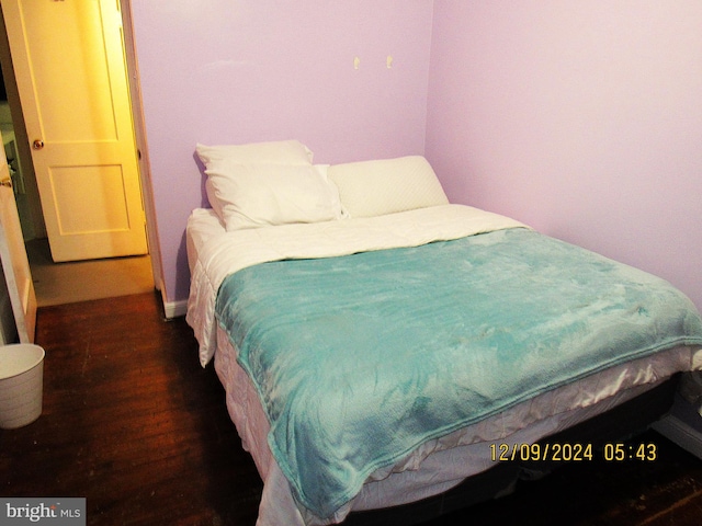 bedroom with dark hardwood / wood-style flooring