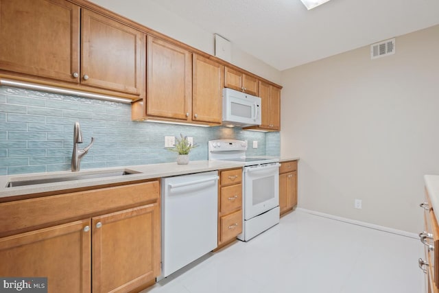 kitchen featuring white appliances, a sink, visible vents, light countertops, and tasteful backsplash