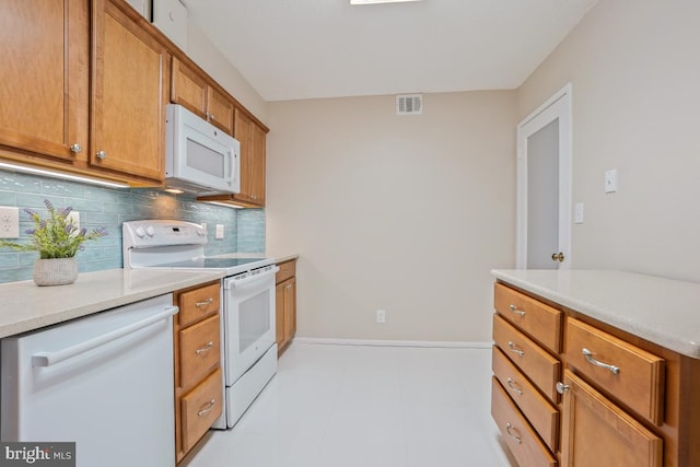 kitchen with tasteful backsplash, light countertops, visible vents, brown cabinetry, and white appliances