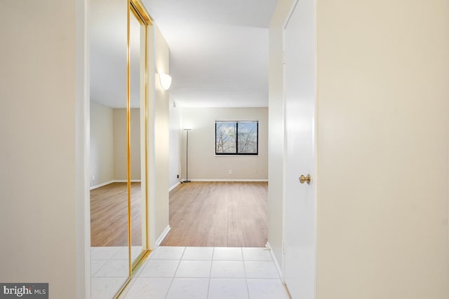 hallway with tile patterned flooring and baseboards