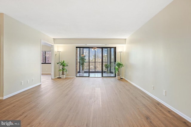 unfurnished living room featuring baseboards and wood finished floors