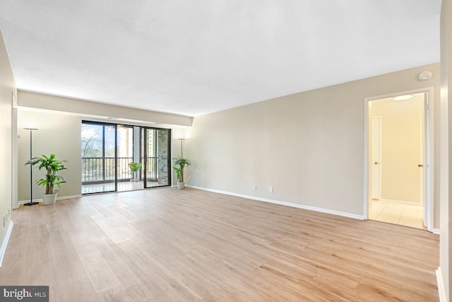 spare room with light wood-type flooring and baseboards