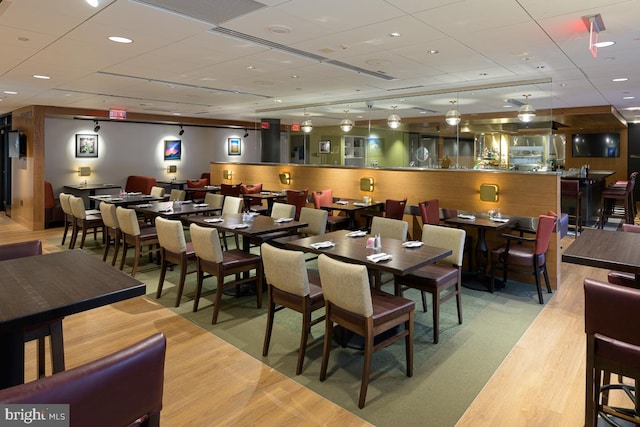 dining area with a paneled ceiling and wood finished floors