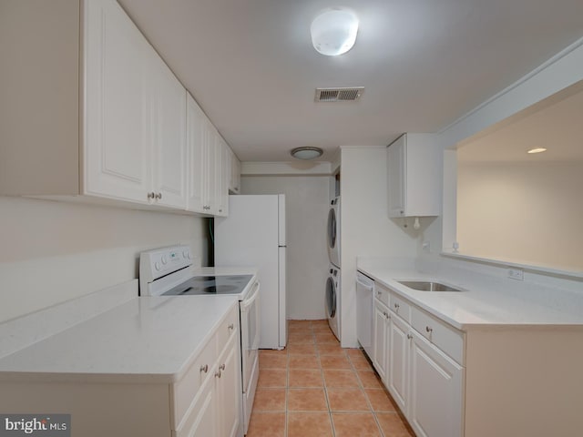 kitchen featuring white cabinetry, sink, white appliances, light tile patterned floors, and stacked washer and clothes dryer