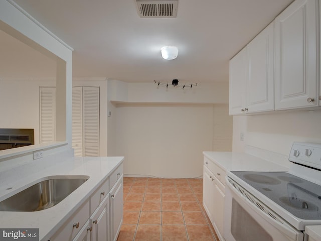 kitchen featuring white range with electric stovetop, white cabinetry, sink, and light tile patterned flooring