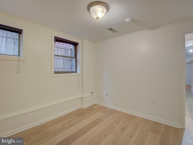 spare room featuring light hardwood / wood-style flooring and crown molding