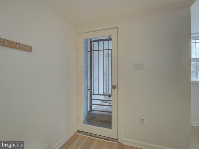 foyer entrance with light wood-type flooring and crown molding