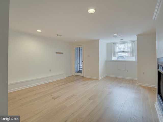 unfurnished living room featuring light hardwood / wood-style floors and ornamental molding