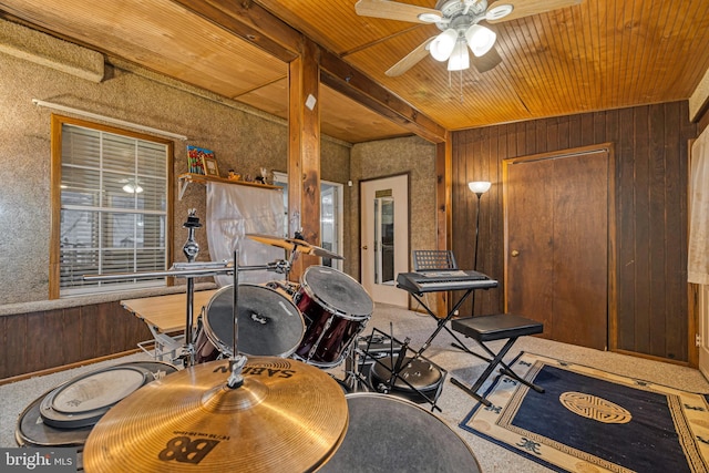 interior space with ceiling fan and wood walls