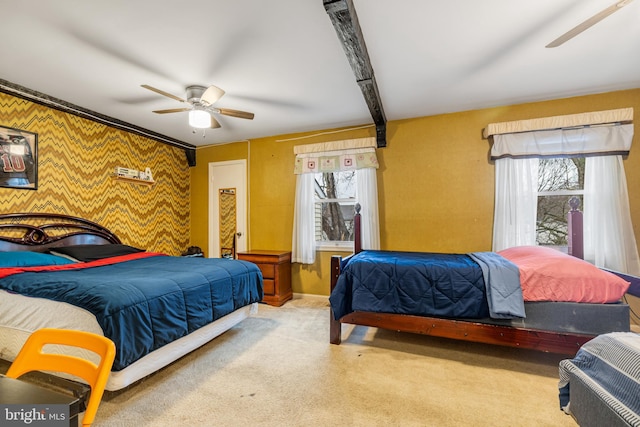 bedroom featuring beam ceiling, light carpet, ceiling fan, and wood walls