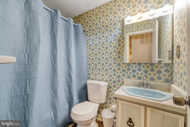 bathroom featuring vanity, toilet, and walk in shower