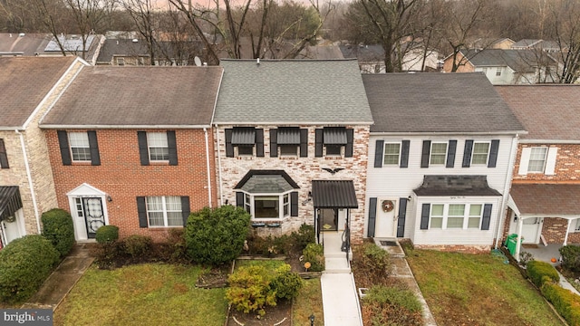 townhome / multi-family property featuring a front yard