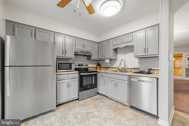 kitchen featuring sink, gray cabinets, ceiling fan, stainless steel appliances, and light carpet