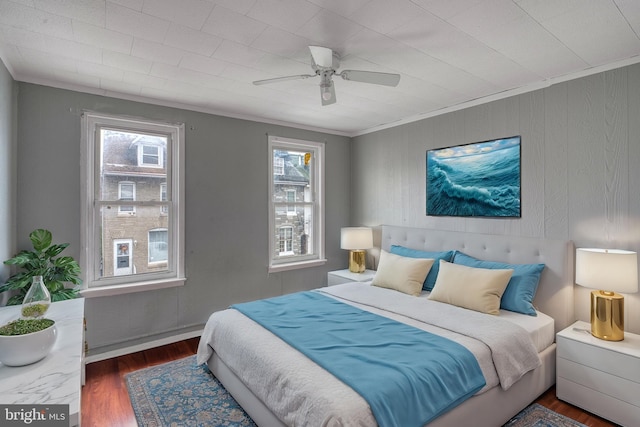 bedroom featuring multiple windows, dark hardwood / wood-style floors, ceiling fan, and ornamental molding