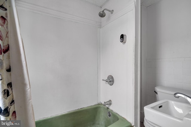 bathroom featuring a textured ceiling, tile walls, and washtub / shower combination