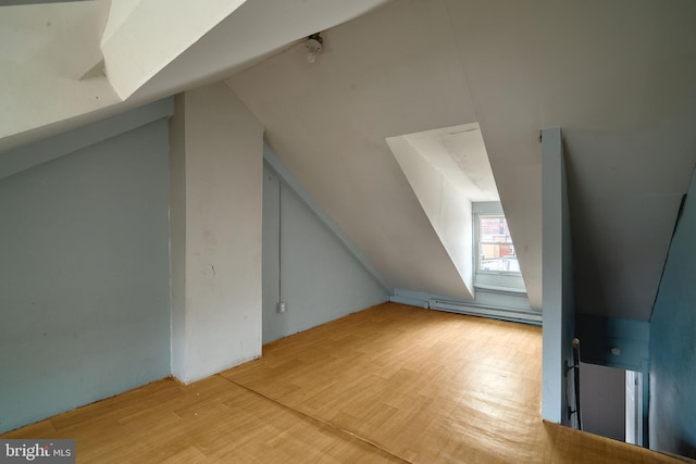 bonus room with baseboard heating, light hardwood / wood-style flooring, and vaulted ceiling