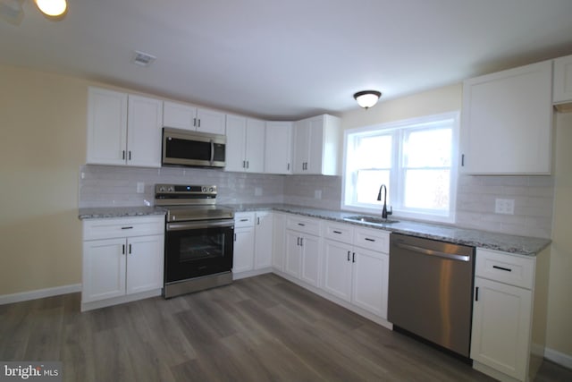 kitchen with dark hardwood / wood-style flooring, stainless steel appliances, white cabinetry, and sink