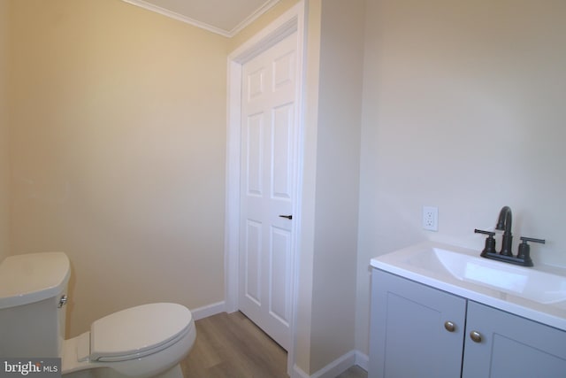 bathroom featuring crown molding, toilet, vanity, and hardwood / wood-style flooring