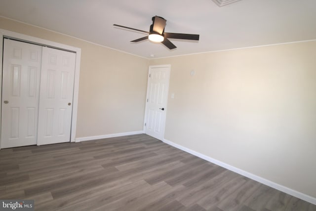 unfurnished bedroom with ceiling fan, a closet, and dark hardwood / wood-style floors