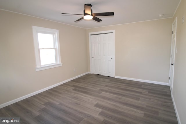 unfurnished bedroom with dark hardwood / wood-style flooring, a closet, and ceiling fan