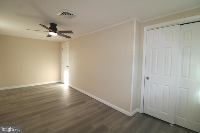 empty room with ceiling fan, dark hardwood / wood-style flooring, and ornamental molding