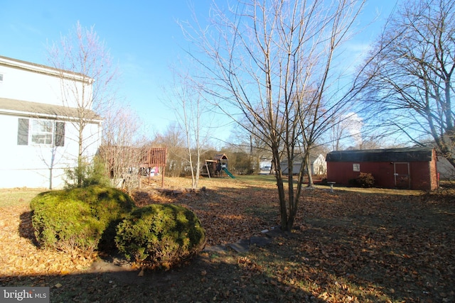 view of yard with a playground and a storage unit