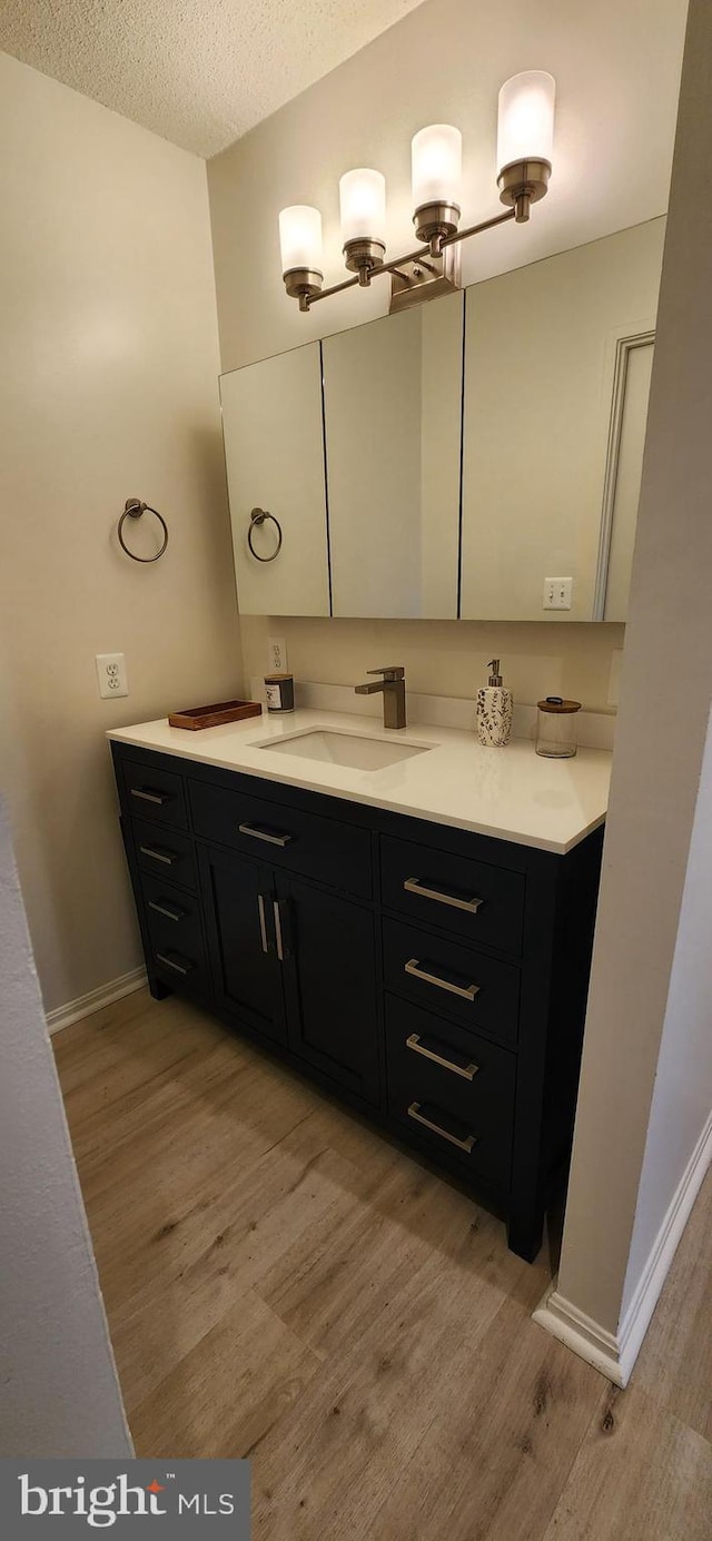 8340 Greensboro Dr Unit 1010, Mclean, VA 22102 - bathroom featuring wood finished floors, vanity, and a textured ceiling