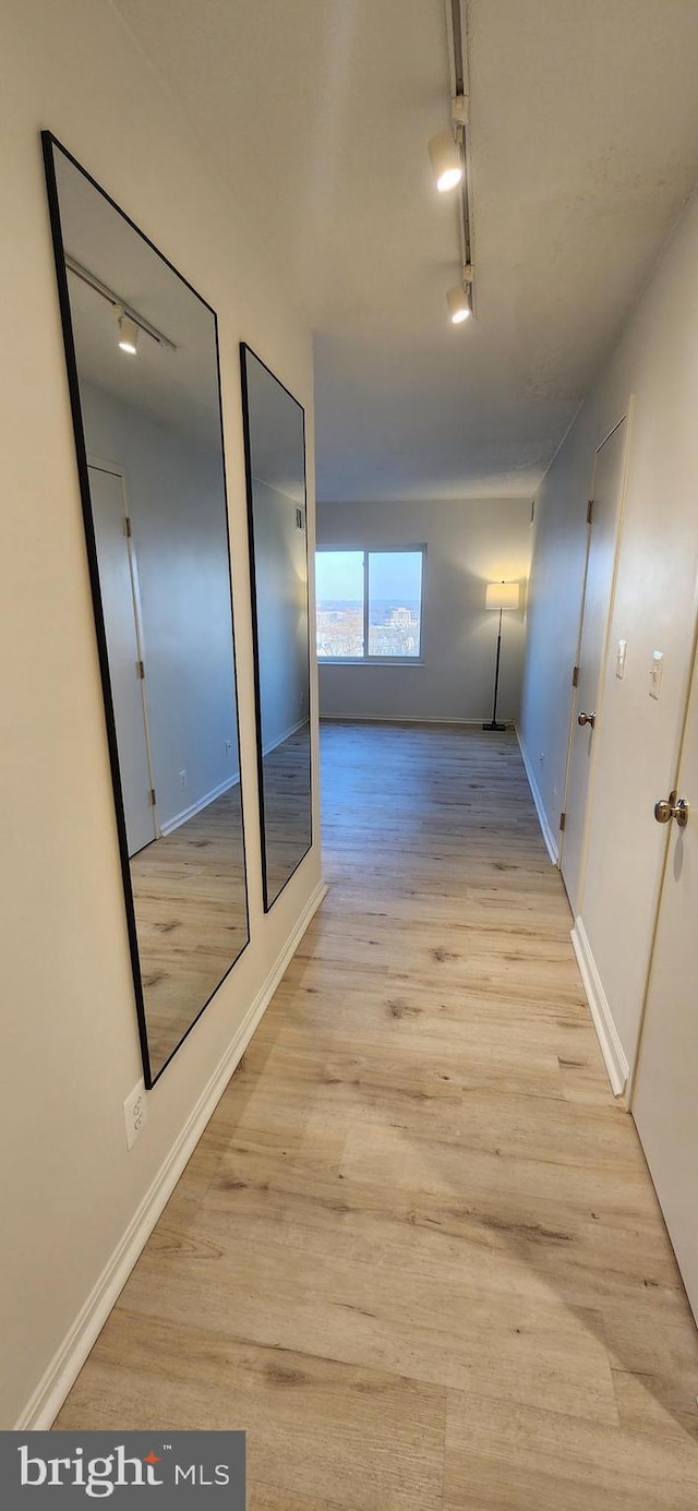 hallway with track lighting and light hardwood / wood-style flooring