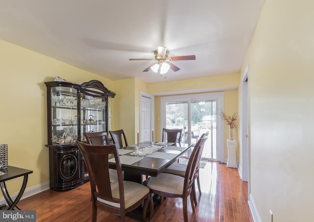 dining space with ceiling fan and dark hardwood / wood-style flooring