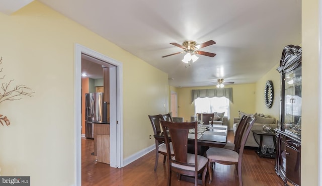 dining space with ceiling fan and dark wood-type flooring