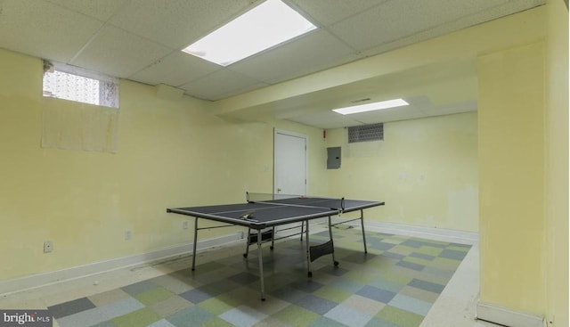 recreation room with electric panel and a drop ceiling