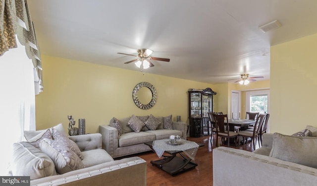 living room featuring ceiling fan and dark wood-type flooring