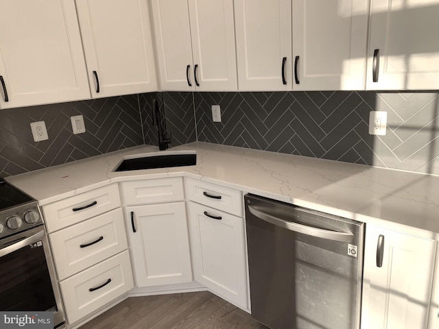 kitchen featuring appliances with stainless steel finishes, dark hardwood / wood-style flooring, white cabinetry, and light stone counters