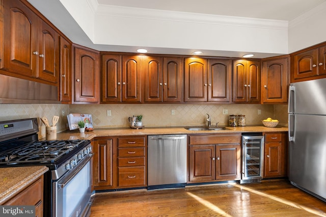 kitchen with sink, crown molding, wine cooler, and appliances with stainless steel finishes