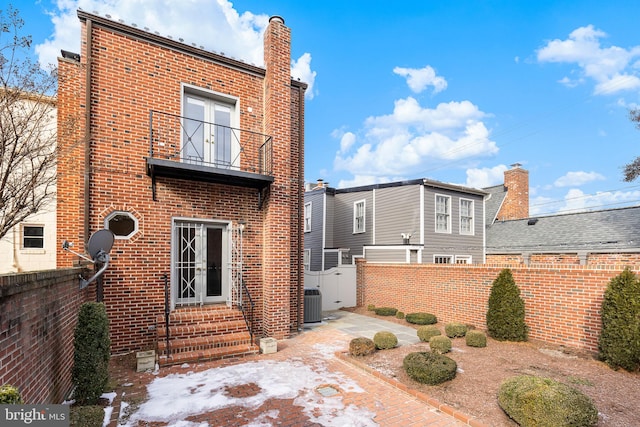 rear view of house featuring a balcony and central AC unit