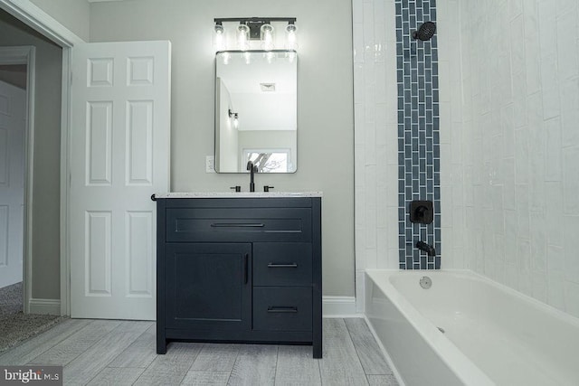 bathroom featuring vanity and tiled shower / bath