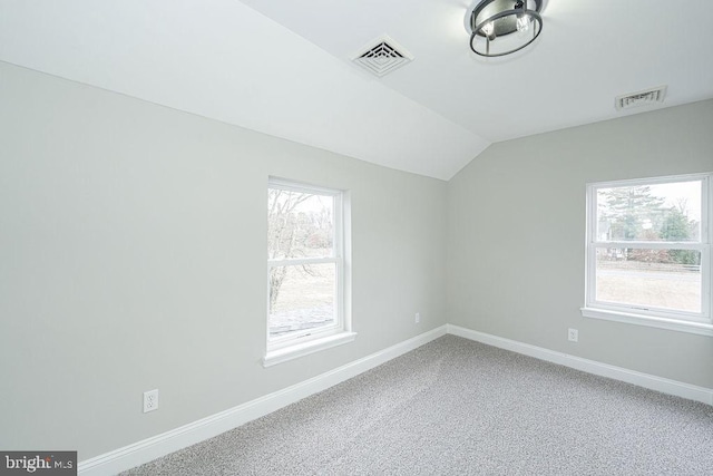 carpeted empty room with lofted ceiling