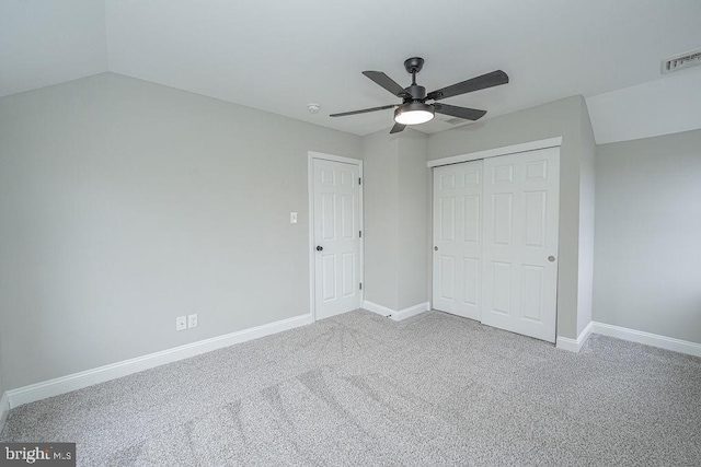 unfurnished bedroom featuring carpet flooring, a closet, ceiling fan, and lofted ceiling