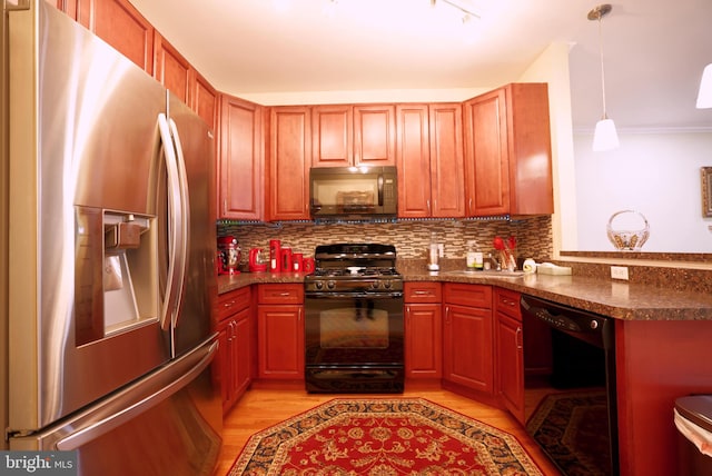 kitchen featuring decorative backsplash, dark stone counters, black appliances, light hardwood / wood-style floors, and hanging light fixtures