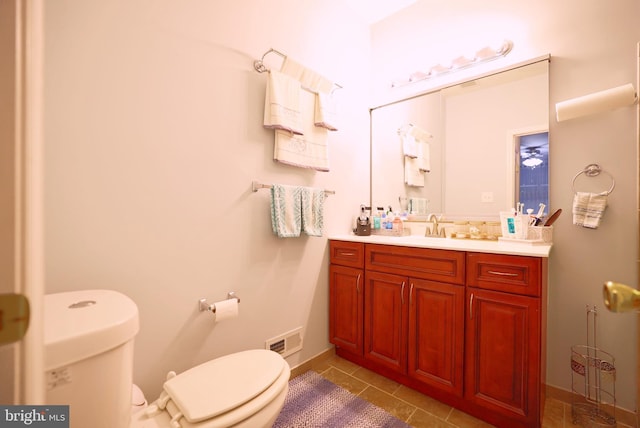 bathroom featuring tile patterned flooring, vanity, and toilet