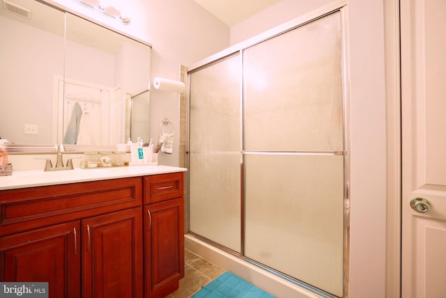 bathroom with tile patterned flooring, vanity, and an enclosed shower