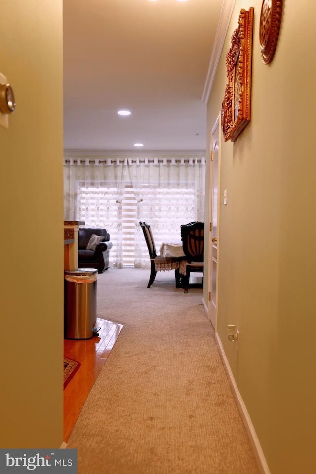 corridor with hardwood / wood-style floors and ornamental molding