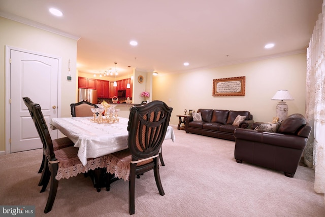 carpeted dining room with ornamental molding