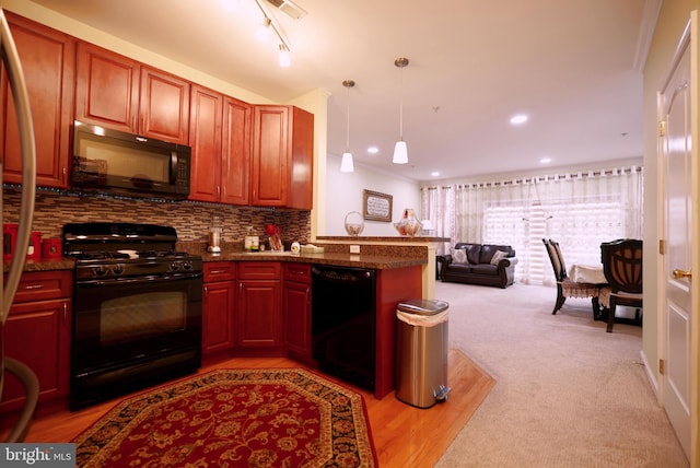 kitchen featuring light carpet, kitchen peninsula, decorative light fixtures, decorative backsplash, and black appliances