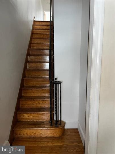 stairs featuring hardwood / wood-style floors