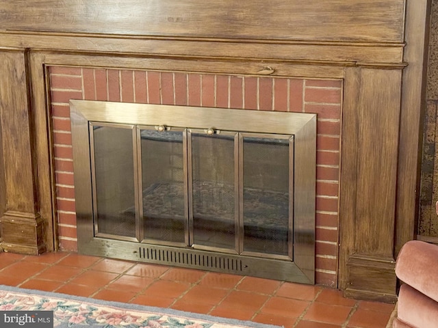 details with wooden walls and a brick fireplace