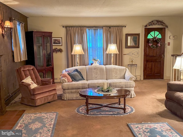 carpeted living room featuring wood walls, a textured ceiling, and a baseboard heating unit